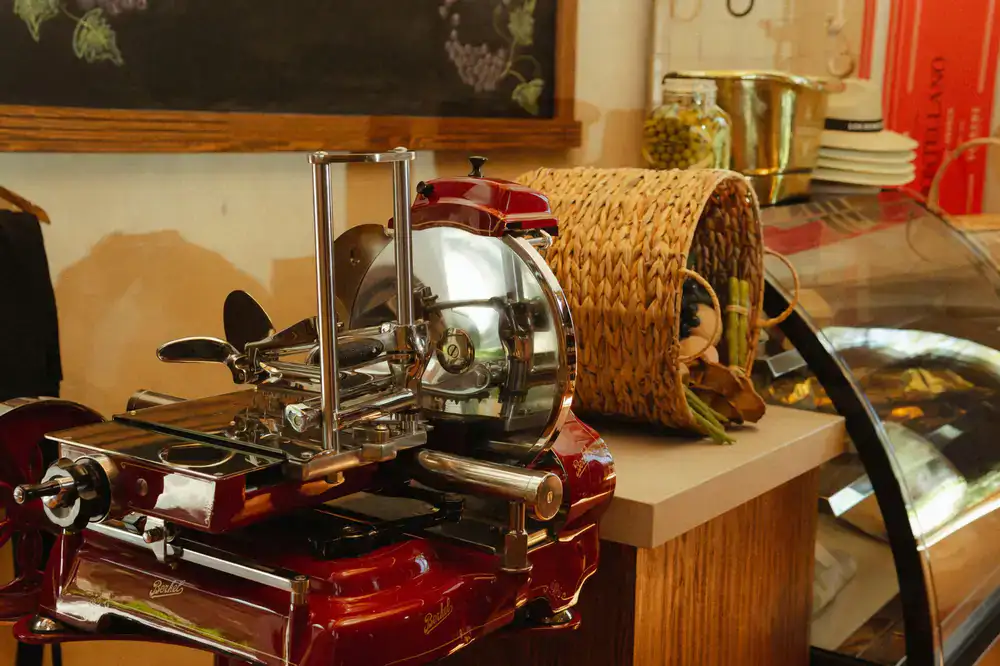 A busy deli counter displaying cured meats and farmhouse cheese