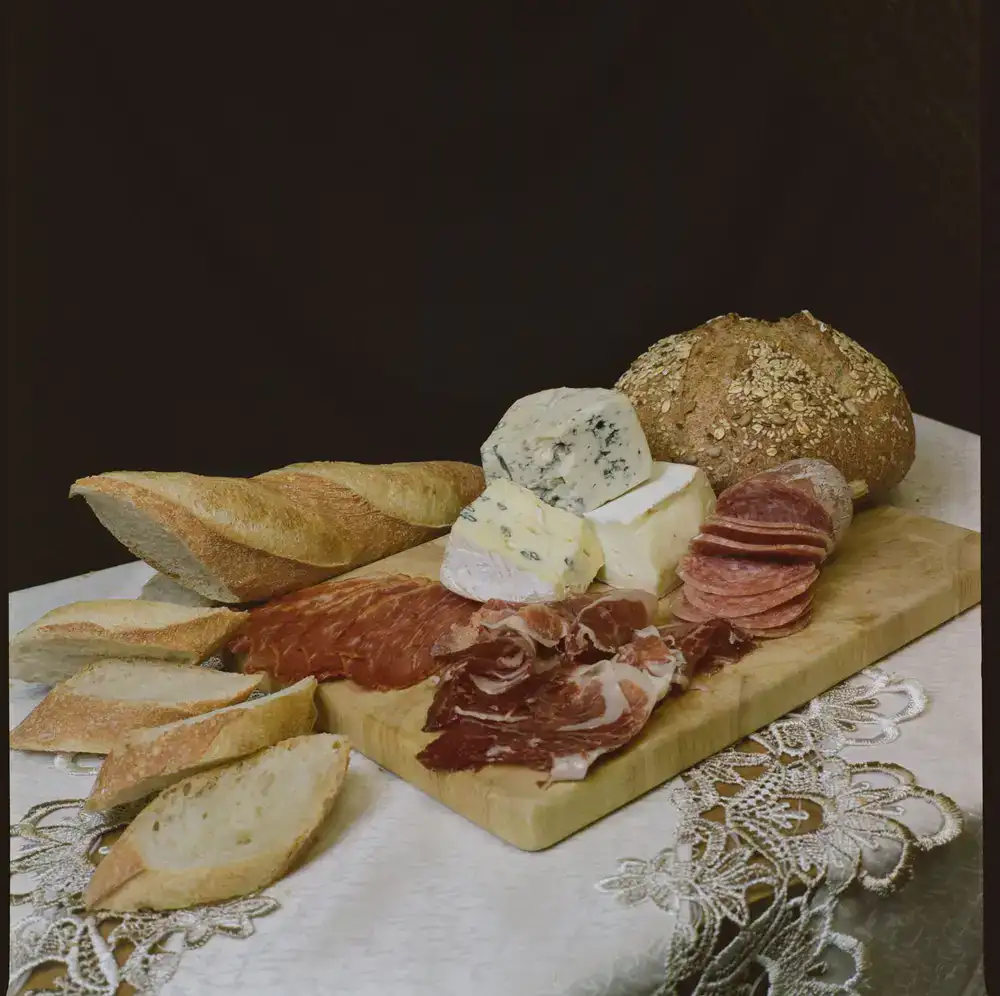 A lavish selection of artisanal cheeses and deli meats on a rustic board